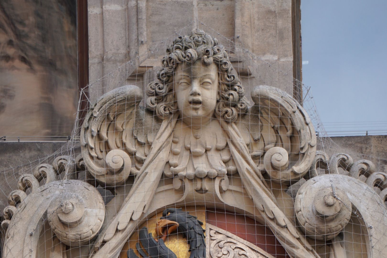 South portal Cartouche crowning with winged putto curly head